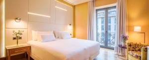 Un dormitorio con una gran cama blanca y una ventana en NH Collection Vigo en Vigo