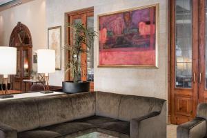 a living room with a couch and a painting at NH Collection Vigo in Vigo