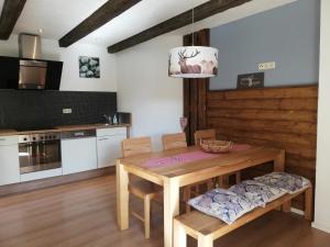 a kitchen with a wooden table and chairs and a dining room at Alp Appartments in Tösens