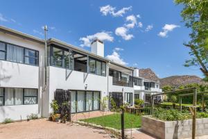 an exterior view of a white building with mountains in the background at Mimosa Lodge in Montagu