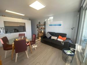 Una sala de estar con un sofá negro y una mesa. en Apartamento Oasis Palmeras 4, en San Bartolomé