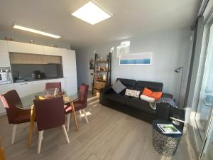 a living room with a black couch and a table at Apartamento Oasis Palmeras 4 in San Bartolomé de Tirajana