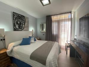 a bedroom with a bed and a desk and a window at Apartamento Oasis Palmeras 4 in San Bartolomé