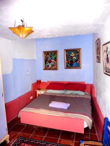 アルアマ・デ・グラナダにあるCasa Isabellaの青い部屋に赤いベッドが備わるベッドルーム1室があります。