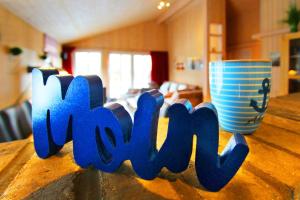 a wooden table with the word kwx next to a cup at Ferienhaus Bogense in Steinbergkirche