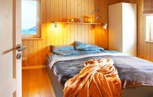 Bett in einem Zimmer mit Holzwänden und einem Fenster in der Unterkunft Ferienhaus Bogense in Steinbergkirche