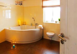 a bathroom with a large tub and a toilet at Ferienhaus Bogense in Steinbergkirche