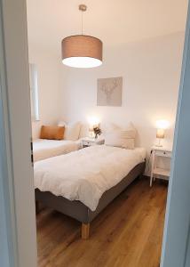 1 dormitorio pequeño con 2 camas y mesa en Wine & Hike, en Wincheringen