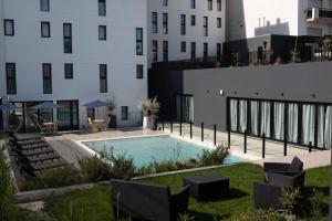 a swimming pool in a yard next to a building at Arena Suites in Mar del Plata