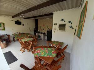 a dining room with tables and chairs with birds on the wall at Suítes Cantinho do Sossego Ubatuba in Ubatuba