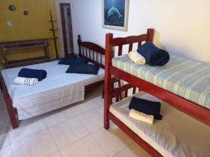 a bedroom with two bunk beds with blue pillows at Suítes Cantinho do Sossego Ubatuba in Ubatuba