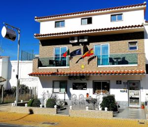 un edificio con una bandera delante en Hostel Boutique Marisol, en Monte Gordo