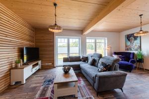 a living room with a couch and a tv at Ferienpark Harkebrügge Haus Juist in Barßel