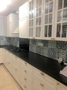 a kitchen with white cabinets and black counter tops at Villa Maimouna les pieds dans l'eau in Saint-Pierre