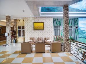 a lobby with chairs and a wall of windows at SUPER OYO Capital O 540 Esther Hotel in Balige