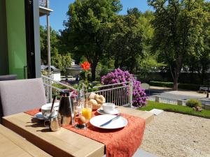 einen Tisch mit einem Teller Essen auf einer Terrasse in der Unterkunft Hotel-Pension Vier Jahreszeiten in Bad Elster