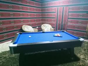 a pool table in a room with two chairs at Infinity Lodge in Wadi Musa