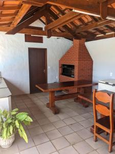 ein Esszimmer mit einem Tisch und einem gemauerten Kamin in der Unterkunft Chácara Santa Terezinha in Serra Negra