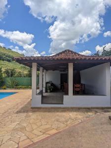 ein Haus mit einer Terrasse und einem Pool in der Unterkunft Chácara Santa Terezinha in Serra Negra