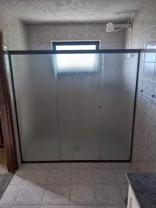 eine große Glasschiebetür im Bad in der Unterkunft Chácara Santa Terezinha in Serra Negra