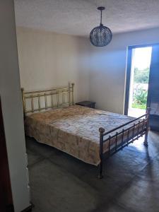ein Schlafzimmer mit einem Bett in einem Zimmer mit einem Fenster in der Unterkunft Chácara Santa Terezinha in Serra Negra