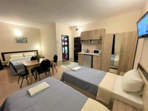 斯維什托夫的住宿－Live Inn Bulgaria town Svishtov，酒店客房设有两张床、一张桌子和一间厨房。