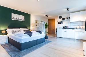 a bedroom with a bed and a green wall at Mercedes I Stuttgart I Kitchen I Home Office I Netflix in Böblingen