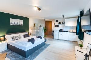a bedroom with a bed and a green wall at Mercedes I Stuttgart I Kitchen I Home Office I Parkplatz in Böblingen