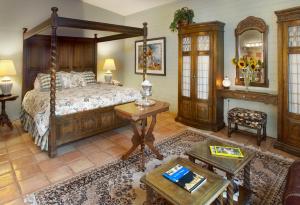 a bedroom with a canopy bed and a table at Cactus Cove Bed and Breakfast Inn in Tucson