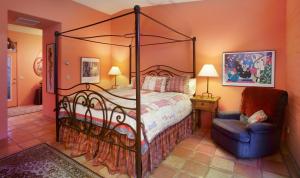 a bedroom with a canopy bed and a chair at Cactus Cove Bed and Breakfast Inn in Tucson +7 photos