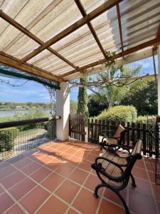 a patio with two chairs and a wooden pergola at Kadie's Landing House - Living The Breede in Malgas