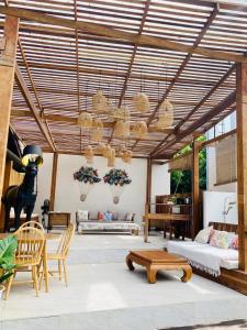 a living room with a wooden ceiling with chairs and tables at Veni Vana Valley Maetang in Ban Chang