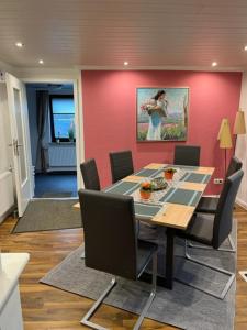 a dining room with a table and a pink wall at Bauernhaus nähe Lamspringe in Winzenburg