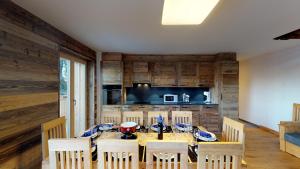 une salle à manger avec une table et des chaises ainsi qu'une cuisine dans l'établissement Les Mayens LUXURY & COSY Duplex, à Veysonnaz