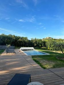 a swimming pool in a yard with a bench at Villa des Mattes - Superbe maison de famille 15 couchages in Crillon-le-Brave
