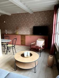 a living room with tables and chairs and a tv at Duplex 50m2 rénové, hyper-centre, St sauveur in Caen