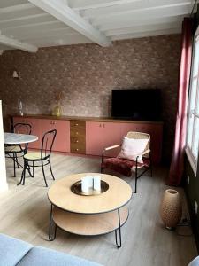 un soggiorno con tavoli, sedie e TV di Duplex 50m2 rénové, hyper-centre, St sauveur a Caen