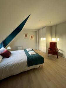 - une chambre avec un grand lit et une chaise dans l'établissement Duplex 50m2 rénové, hyper-centre, St sauveur, à Caen