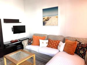 - un salon avec un canapé et une télévision dans l'établissement APARTAMENTO SOL PLAYA, à Punta de Mujeres