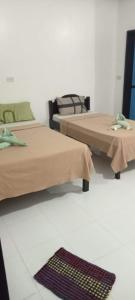 two beds in a room with a rug on the floor at Dreamland Nilo Eve Beach Guest Huaz in El Nido