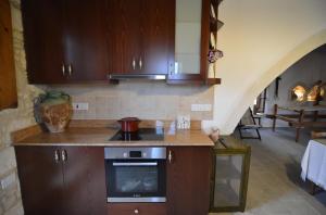 a kitchen with wooden cabinets and a stove top oven at Aliki's House 1+ 2 in Polis Chrysochous