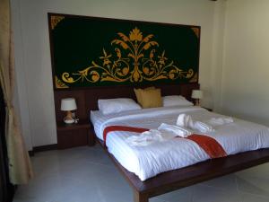 2 Einzelbetten in einem Zimmer mit grüner Wand in der Unterkunft PARADIS VERT in Ban Khao Thong