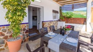 a patio with a table and chairs and a plant at Casa Amberes Torrox by Ruralidays in Torrox