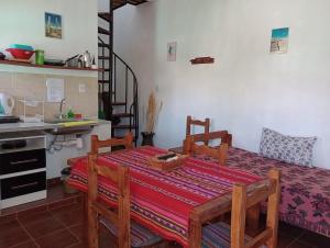 a dining room with a table and a kitchen at Altos Valles del Sol in Cafayate