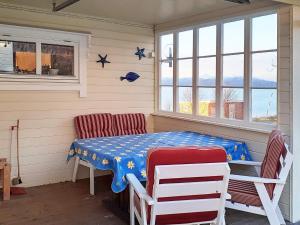 um quarto com uma mesa, cadeiras e janelas em Holiday home Finnsnes em Finnsnes