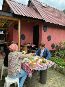 zwei Frauen an einem Tisch vor einem Haus in der Unterkunft Nokta evler 