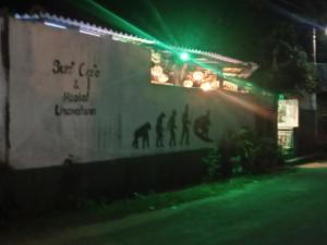 a building with a sign that says out cat is a musical instrument at Hostel Taru surf camp and restaurant in Unawatuna