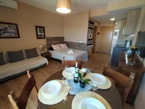een woonkamer met een eettafel en een bank bij Vive Benalmadena, Estudio Benal Beach 2-501, vistas al mar y parque acuático in Benalmádena