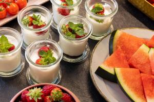 uma mesa coberta com copos de iogurte e fruta em Hotel Fior d'Aliza em Paris