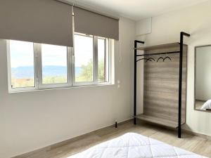 um quarto com uma cama de dossel e 2 janelas em ενtreé guest house near Palamidi Castle em Nafplio